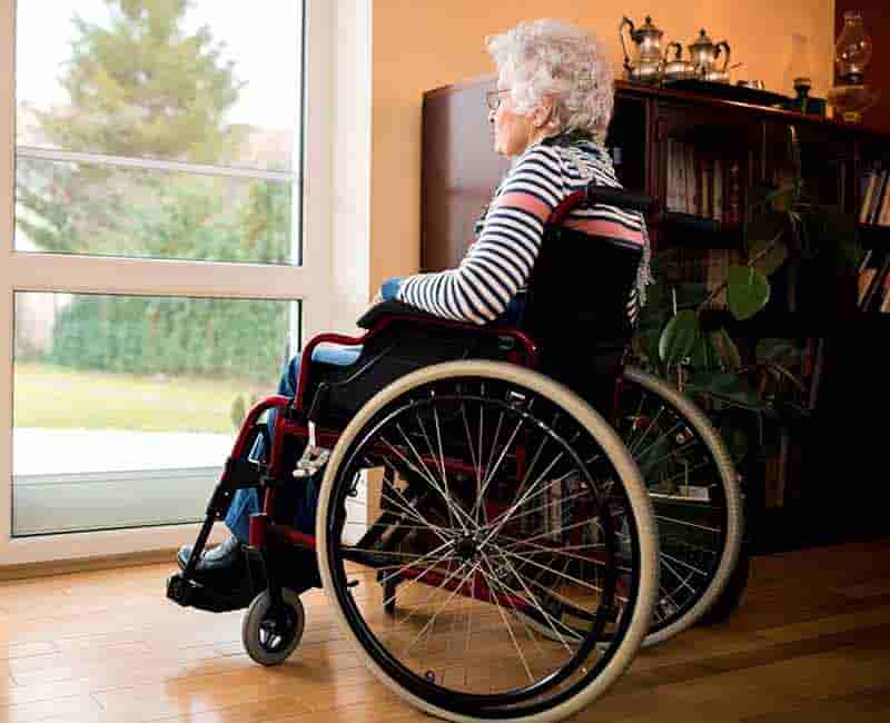 Woman in wheelchair looking out window